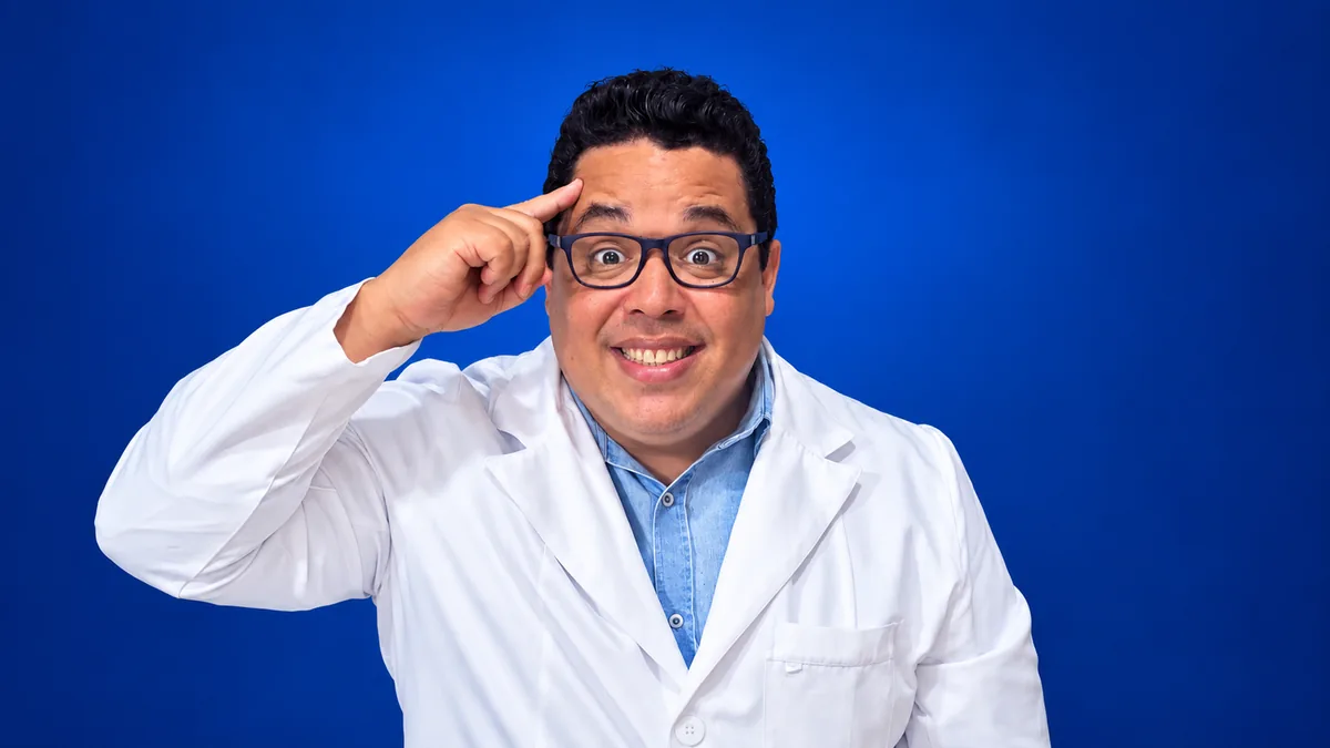 Professor Thiago Santos com o dedo na têmpora, em fundo azul
